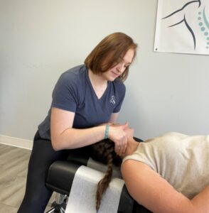 A picture of Dr. Olivia adjusting a patient with a headache.